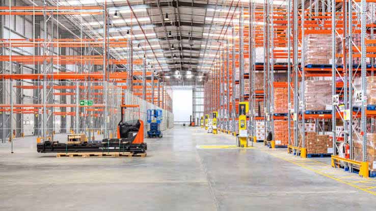 Steel logistics warehouse interior with high-bay racking and protective access aisle.